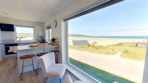 A modern kitchen with a large window overlooking a beach. - B27 The Lair, Riviere Towans (Hayle)