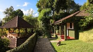 A garden with a gazebo, a covered seating area, and a pathway. - Cardamom County by Xandari (Peermade)