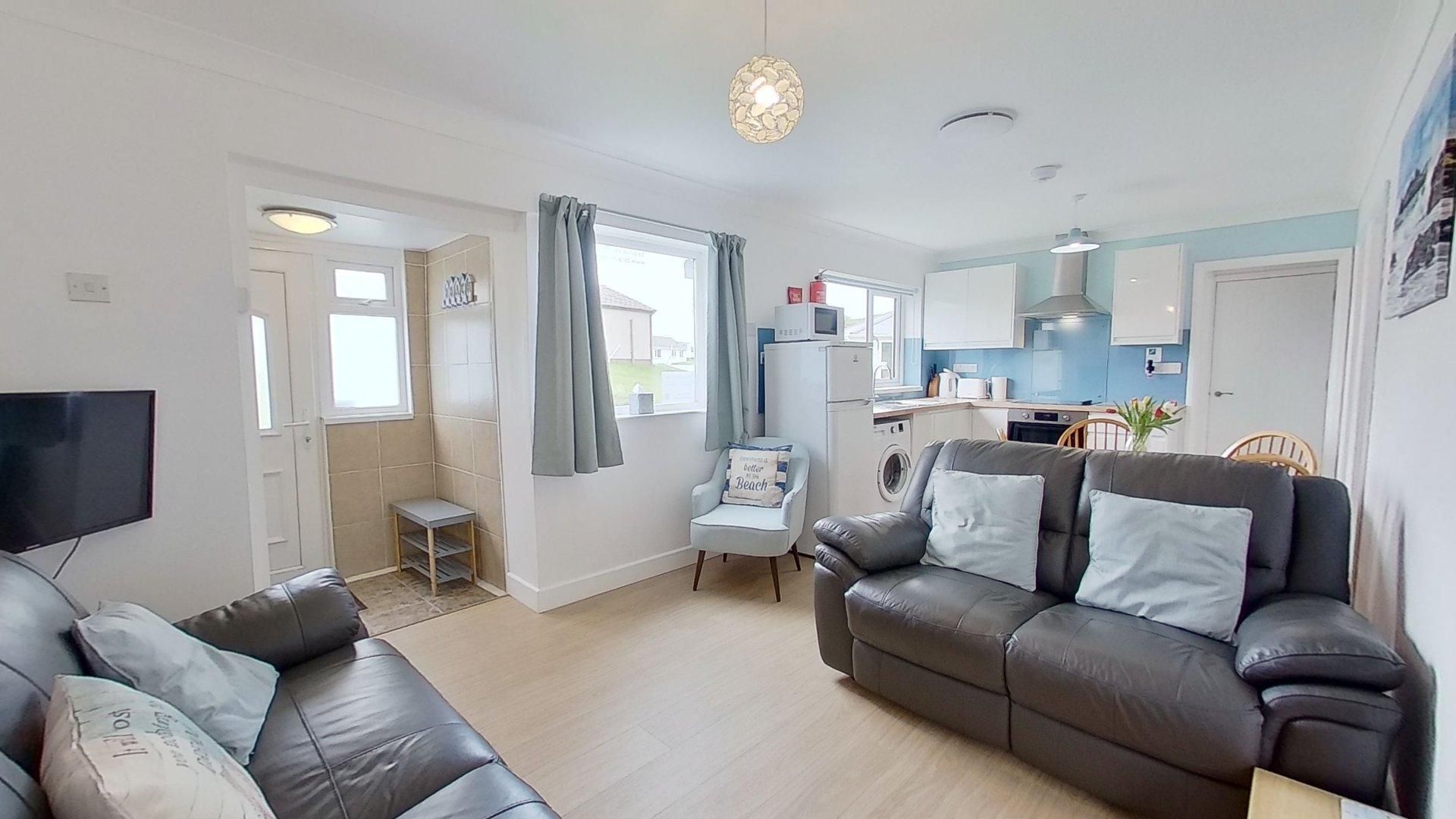 A modern living room with a sofa, a television, and a small table.