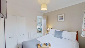 A bedroom with a bed, bedside table, and a wardrobe. - B04 Beachcroft (B4), Riviere Towans (Hayle)