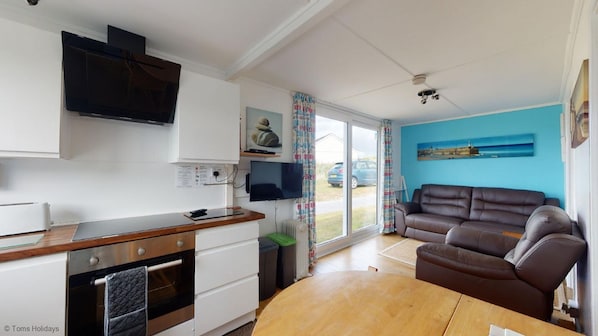 Cozy living space with a kitchenette, sofa, and large window offering a view of the outdoors.