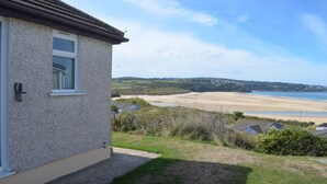 Ein Küstenhaus mit Blick auf Strand und Hügel.