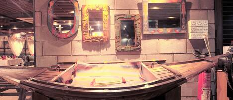 A wooden boat display with ornate mirrors on the wall.