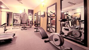A gym with various exercise equipment, including treadmills, stationary bikes, and weight machines. - Well Park Residence Boutique Hotel (Chittagong)