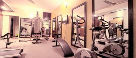 A gym with various exercise equipment, including treadmills, stationary bikes, and weight machines.