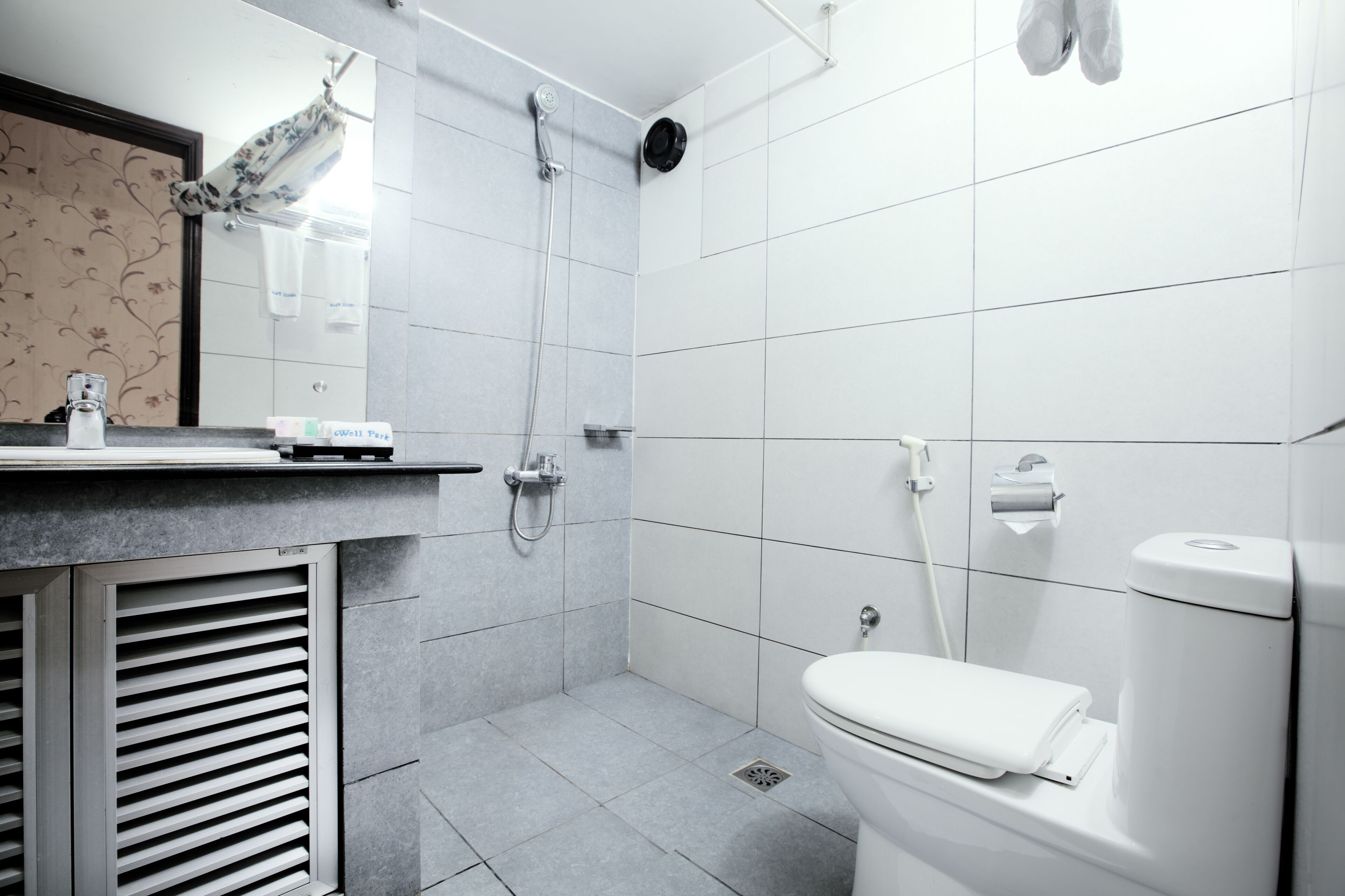 A modern bathroom with a shower, toilet, and sink.
