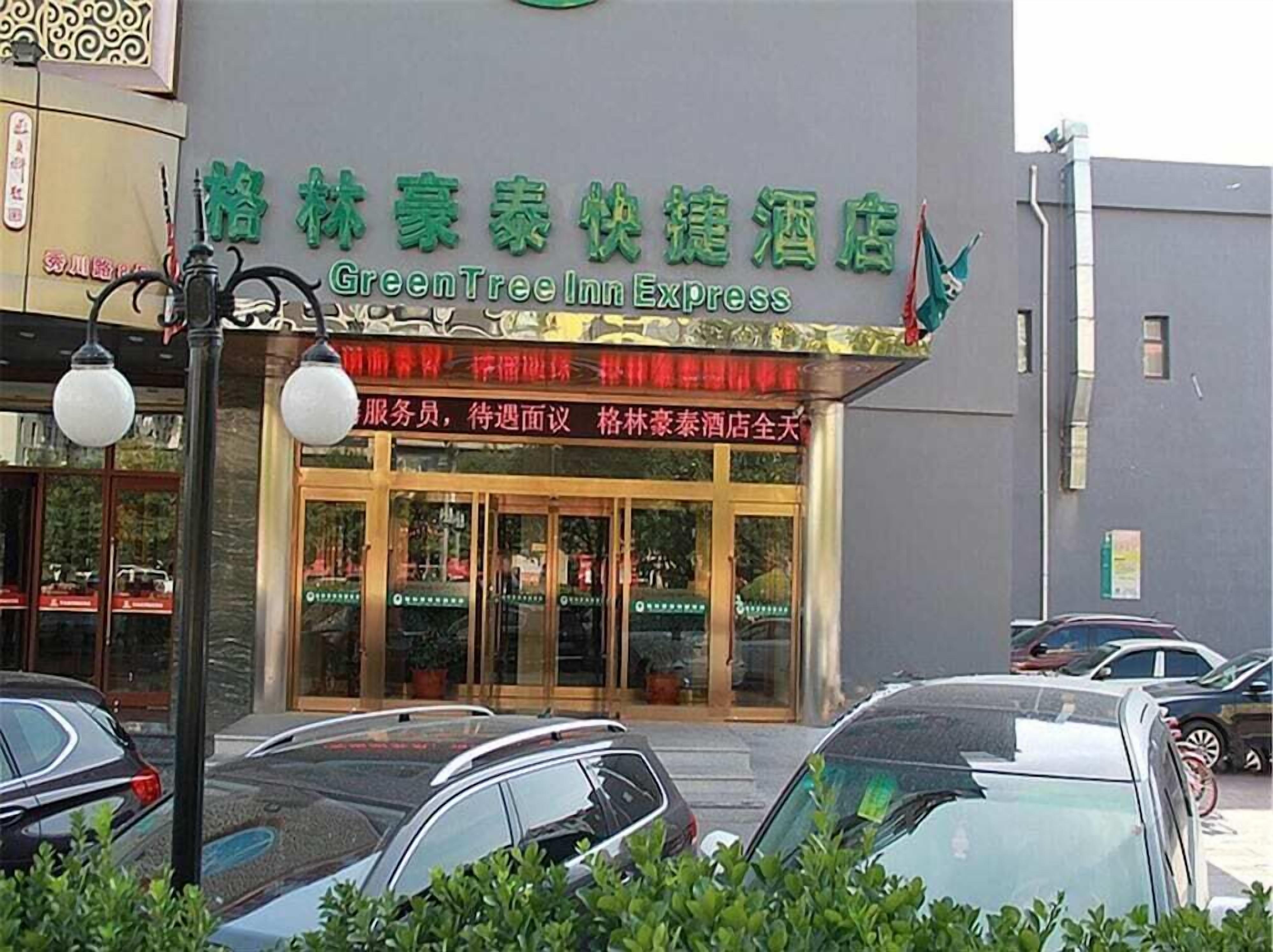 A hotel entrance with a sign for GreenTree Inn Express.