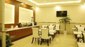 A hotel lobby with a reception desk, seating area, and a television mounted on the wall. - Greentree Sunshine 100 Express Hotel (Tianjin)
