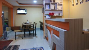 A hotel room with a dining area, a TV mounted on the wall, and a reception desk. - Hotel Peace Mountain (Kathmandu)