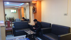 A living room with a sofa, a coffee table, and a patterned rug. - Hotel Peace Mountain (Kathmandu)