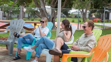 Una piscina al aire libre, sombrillas, sillones reclinables de piscina