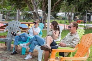Una piscina al aire libre, sombrillas, sillones reclinables de piscina