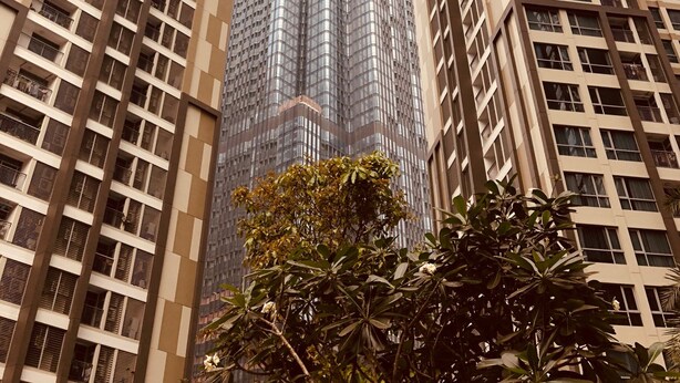 Ein Hochhaus mit modernem architektonischen Design, gekennzeichnet durch eine markante Glasfassade und ein auffälliges Zickzack-Muster in den oberen Stockwerken.