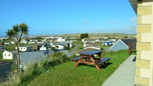 Zona residencial con casas, una mesa de picnic y vista despejada al mar.