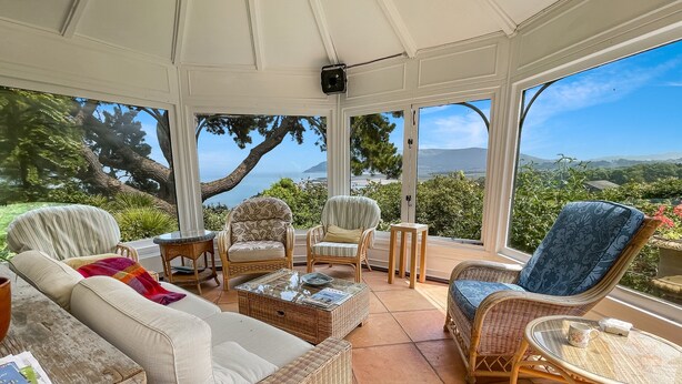 A sunroom with wicker furniture, a glass coffee table, and a view of the sea. - Chapel Knap, Porlock Weir (Porlock Weir)