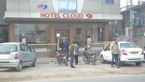 A hotel named 'Hotel Cloud 9' with a modern facade, a gated entrance, and parked motorcycles and cars outside. - Hotel cloud 9 (Madhubani)