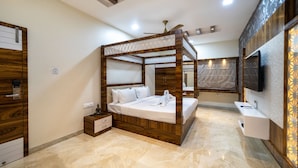 Une chambre moderne avec un lit à baldaquin en bois, un téléviseur à écran plat et une armoire intégrée.