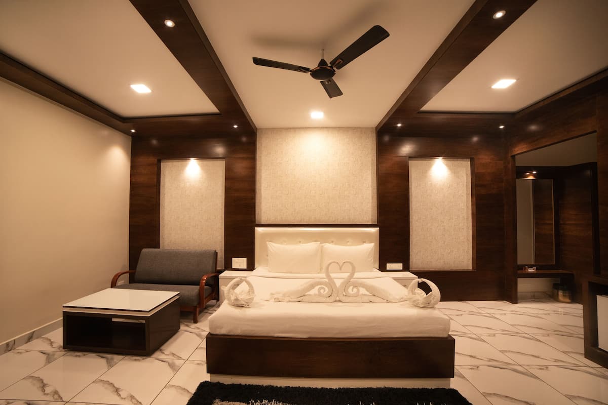A modern bedroom with a large bed, a ceiling fan, and a marble-tiled floor.