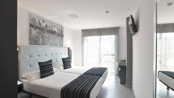 Ein Hotelzimmer mit einem großen Bett, einem an der Wand montierten Fernseher und einem Stadtbild über dem Bett.