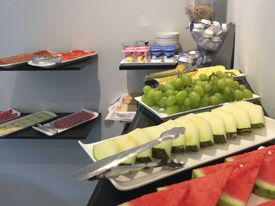 A buffet with various food items including watermelon slices, grapes, and cheese.