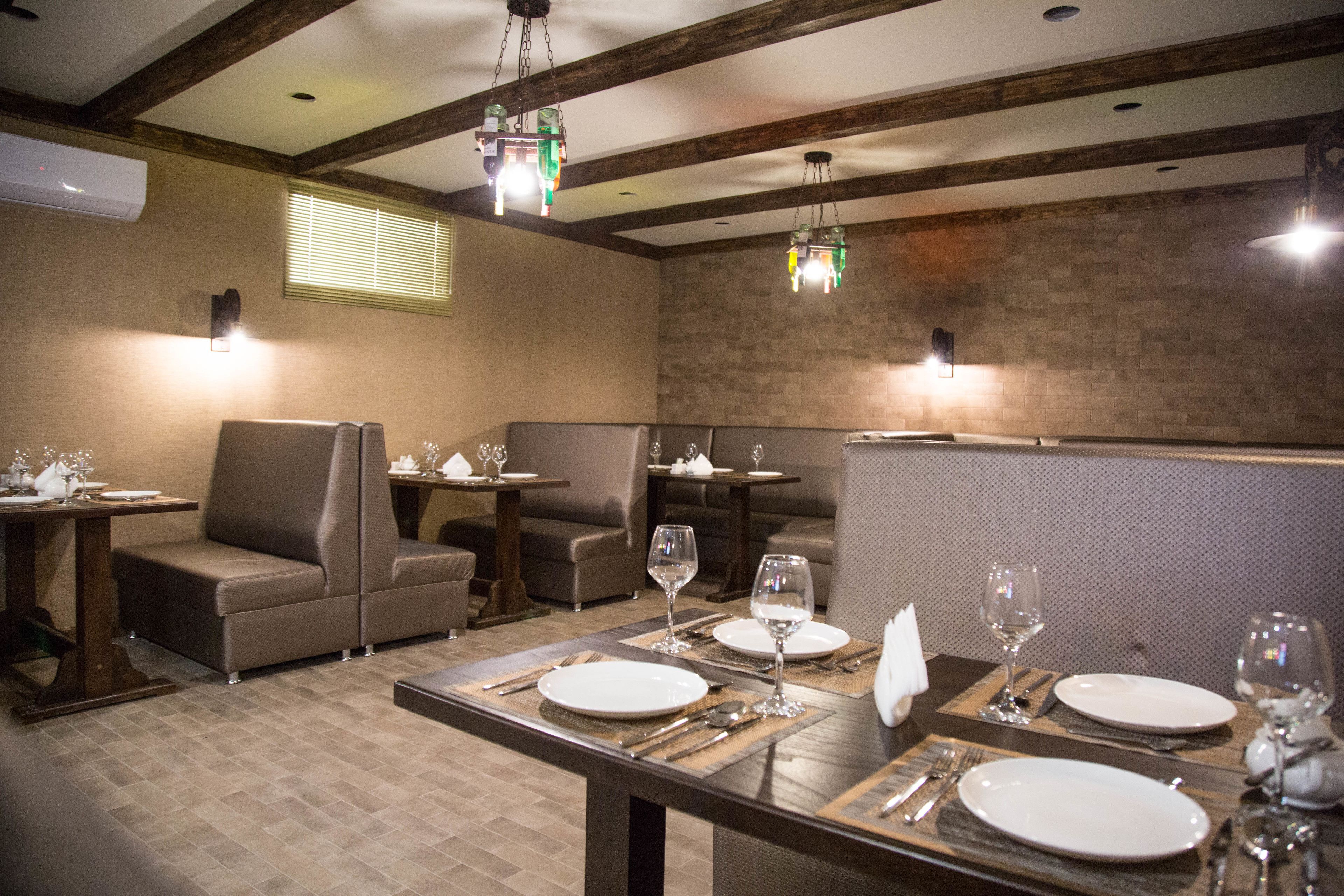 Un restaurant amb seients tipo cabina, taules i llums penjants.
