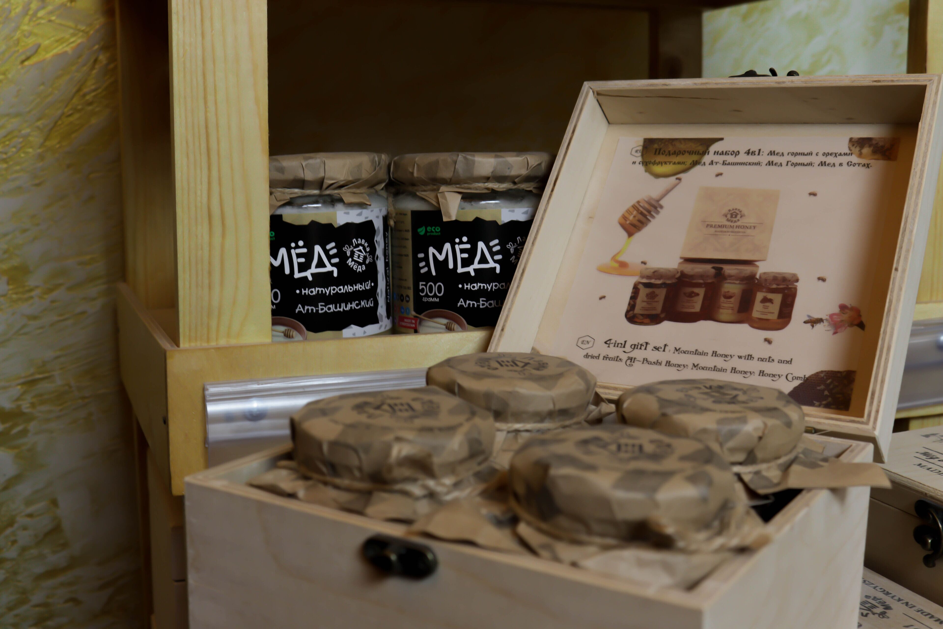 A wooden box with honey jars and a framed picture of honey jars.