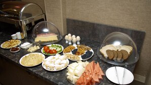 A buffet with various food items including bread, pastries, fruits, and vegetables. - De'Mar Hotel (Bishkek)