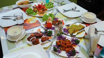 Una mesa dispuesta con diversos platos, incluyendo un tazón de sopa, una ensalada y varias fuentes de comida.