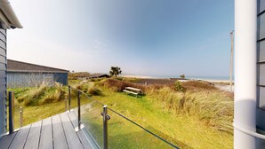 A coastal view from a balcony with a wooden deck, a bench, and a view of the beach and ocean. - B32 Swiss Chalet, Riviere Towans (Hayle)