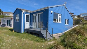 A blue house with a porch, a door, and a window. - B32 Swiss Chalet, Riviere Towans (Hayle)