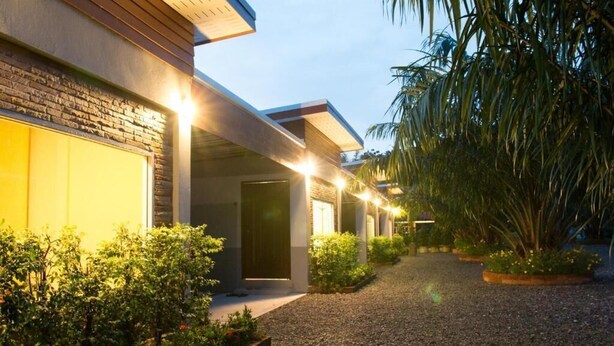 A modern building with a gravel driveway and well-maintained landscaping.