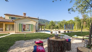 Una villa con patio, mobiliario exterior y vistas a las montañas.