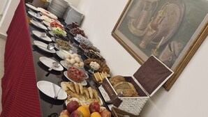 Una mesa de buffet con diversos alimentos, platos y cubiertos.