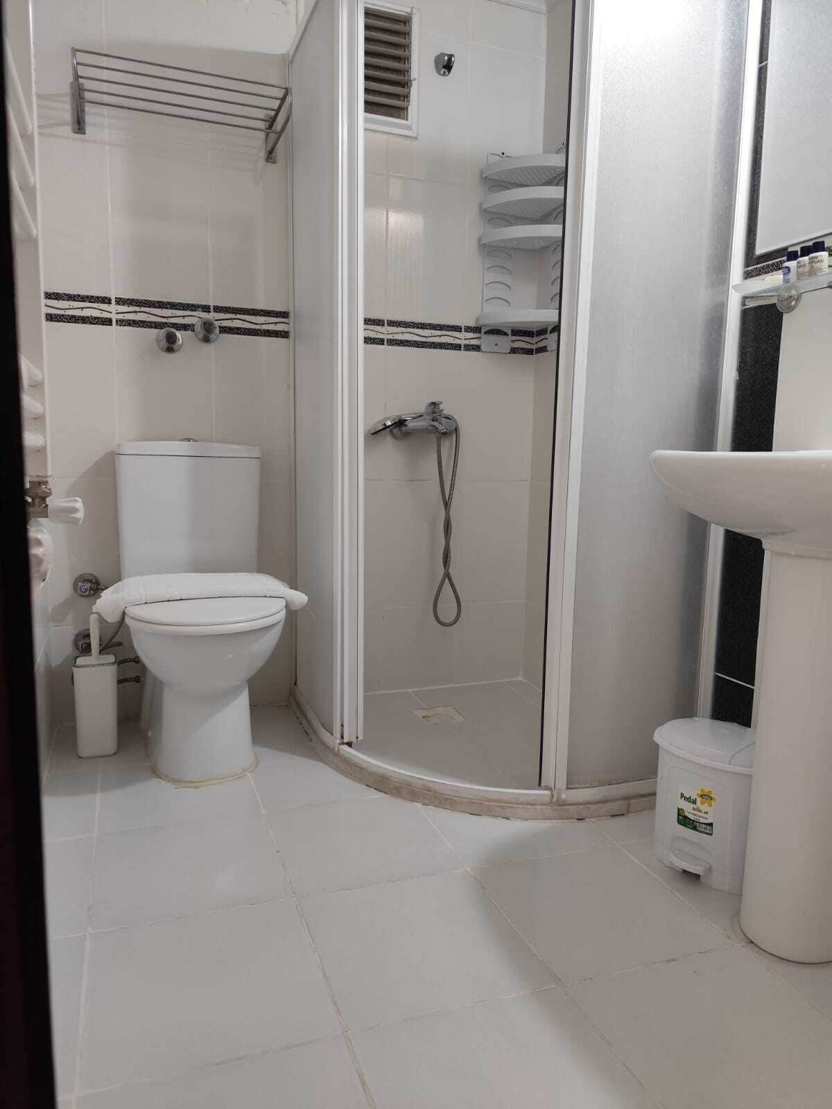 Un baño con inodoro, cabina de ducha y lavabo.