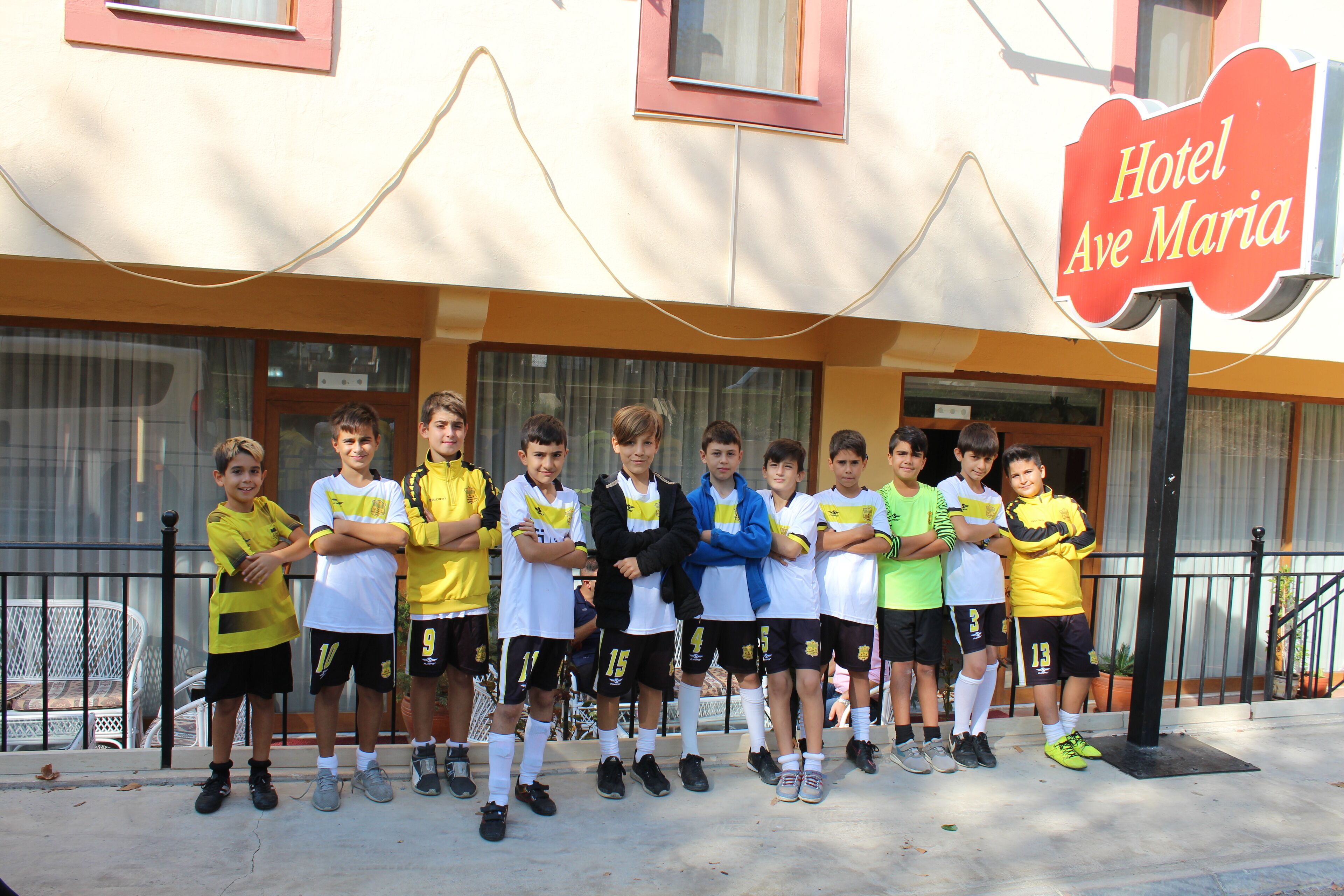 A group of children standing in front of Hotel Ave Maria.