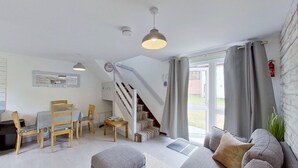 Un intérieur moderne comprenant un escalier, un coin repas et un espace salon.