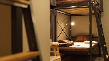 A bunk bed room with a ladder, a small table, and a chair.