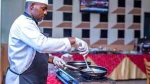 A chef in a white uniform and hat cooking on a portable stove. - Kigaliview Hotel & Apartaments (Kigali)