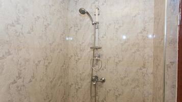 Une douche équipée d’un pommeau de douche à main et d’un robinet mural.