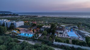 Ein Resort mit Pool, Zugang zum Strand und einem großen Gebäudekomplex.