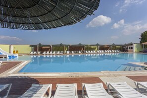 A swimming pool with lounge chairs and a shaded area. - Hedef Beyt Hotel Resort & Spa (Selçuk)