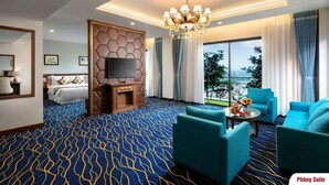 A hotel room with a large bed, a TV, a chandelier, and a view of the outdoors. - Phoenix Resort Bac Ninh (Vu Ninh)