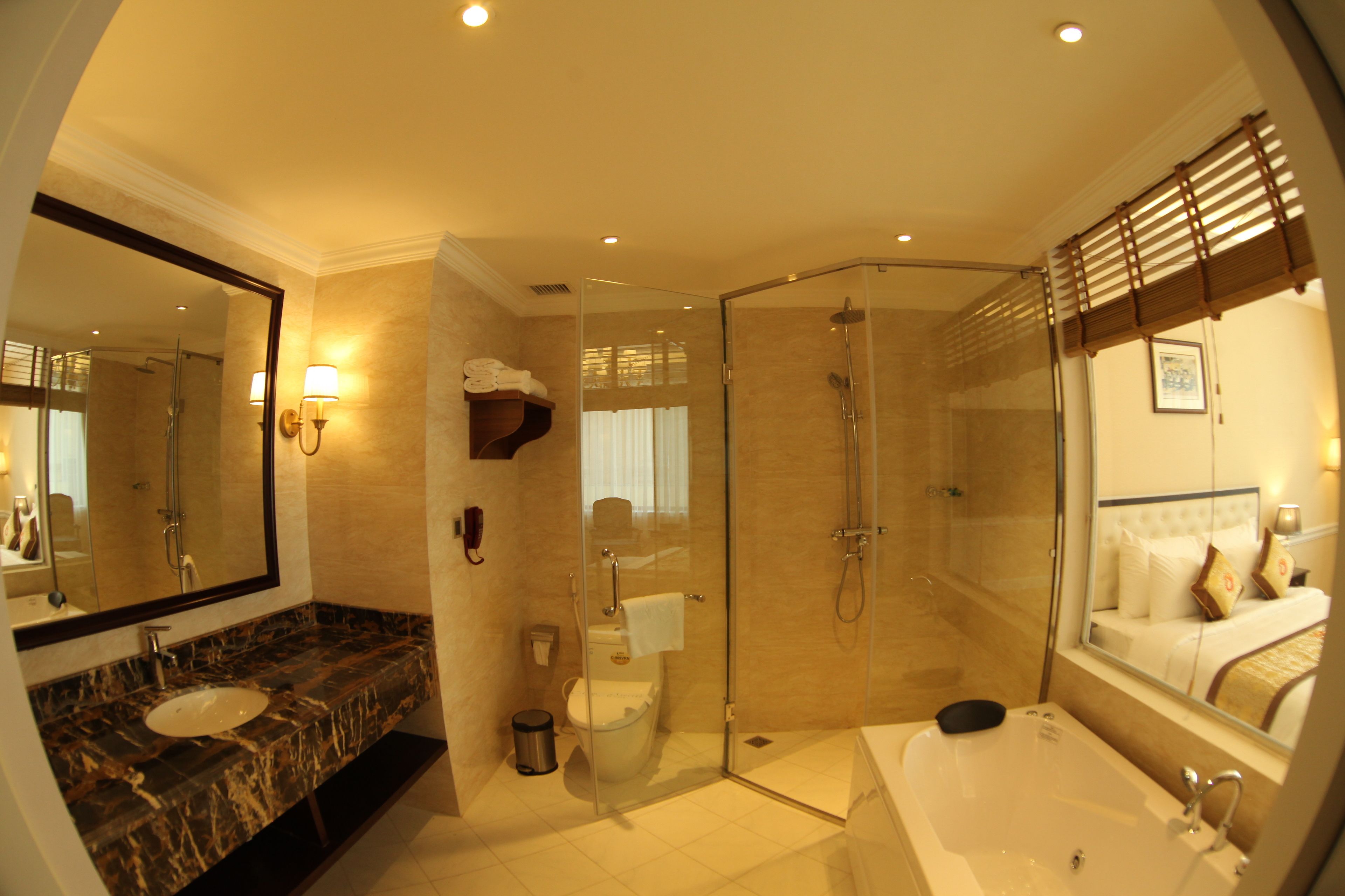A modern bathroom with a marble sink, a glass-enclosed shower, and a large mirror.