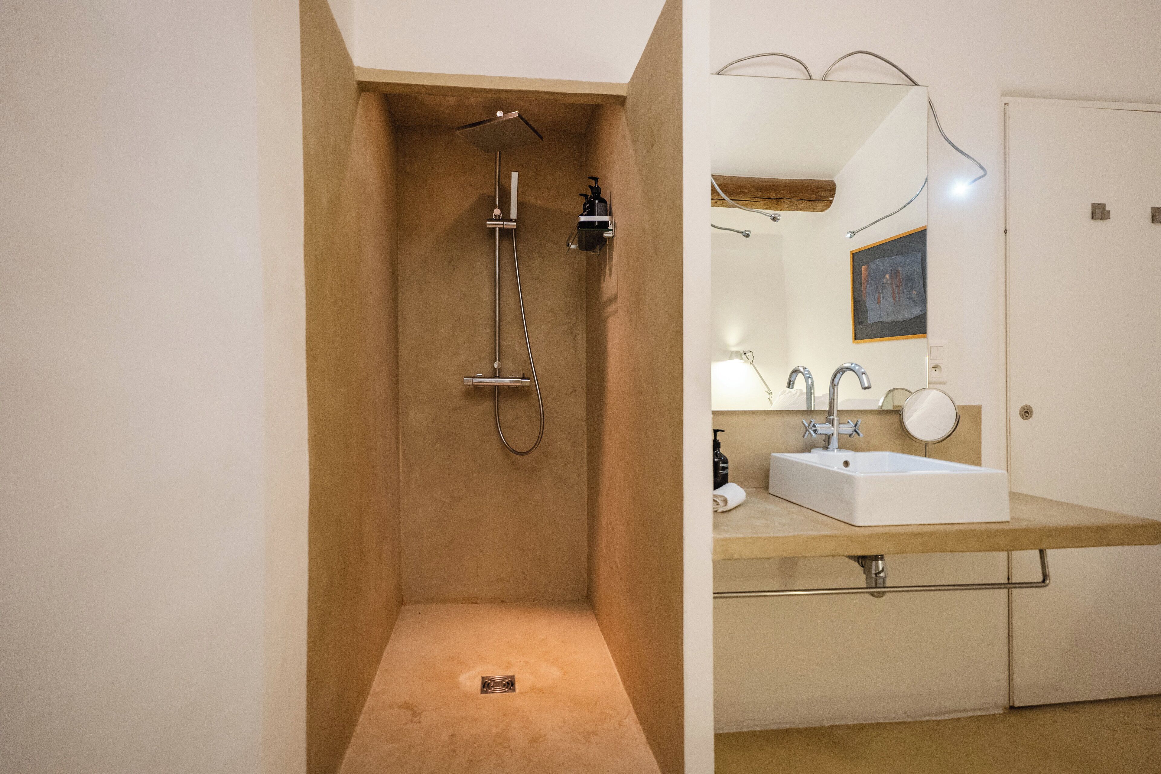 A modern bathroom with a shower, a sink, and a mirror.