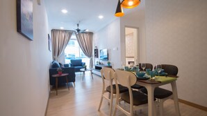 Una sala de estar moderna con un sofá, una mesa de comedor para dos personas y un ventilador de techo.