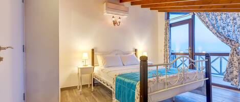 A bedroom with a bed, a nightstand, an air conditioning unit, and a window with curtains.