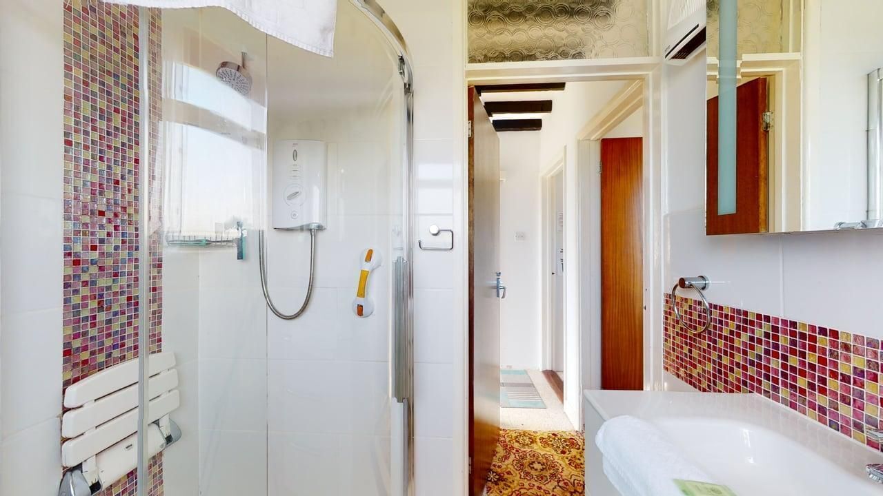 A bathroom with a shower, a toilet, and a sink.