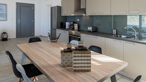 Una cucina moderna con un tavolo di legno, sedie e lampade a sospensione.