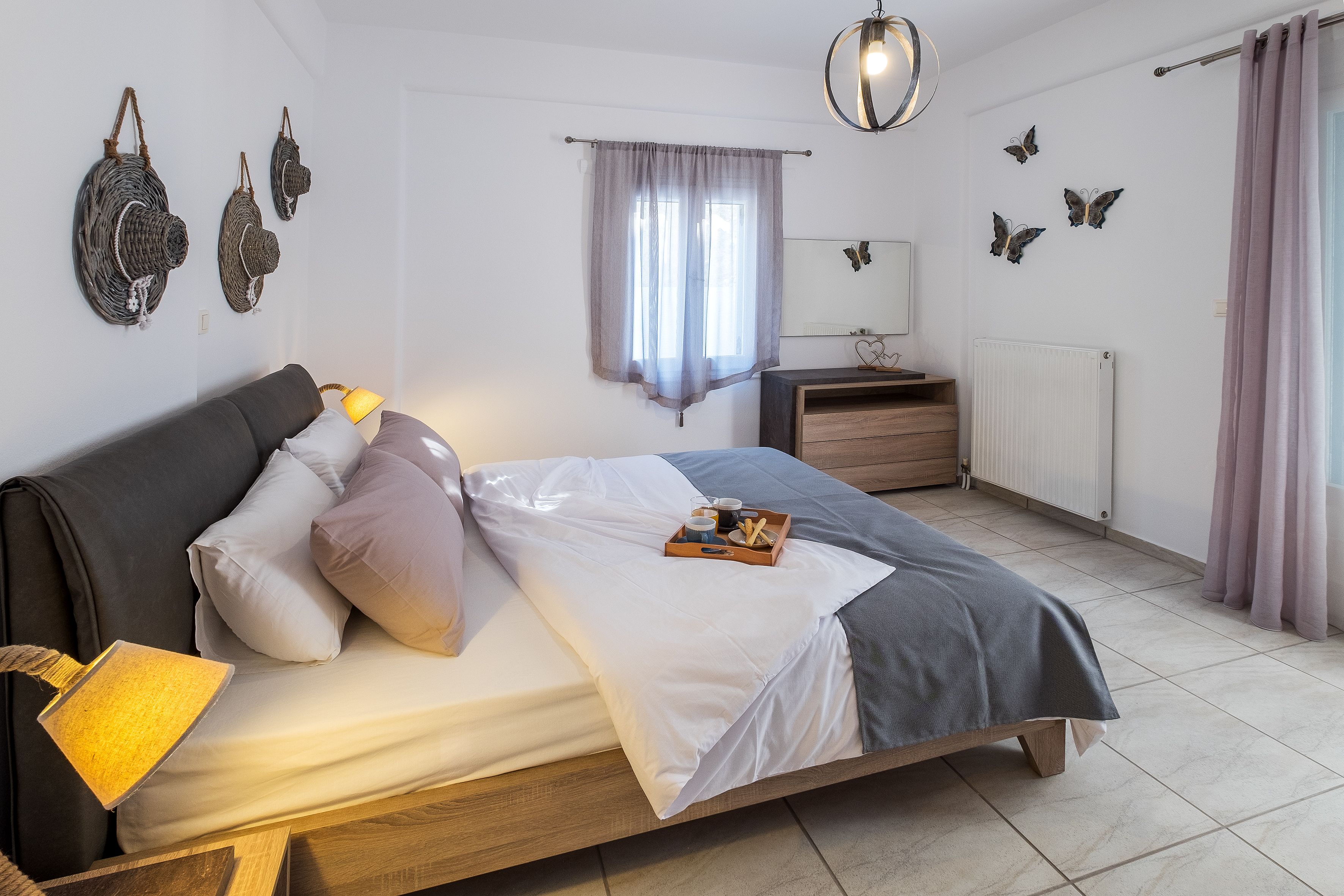 A neatly arranged bedroom with a bed, bedside table, and a window with curtains.