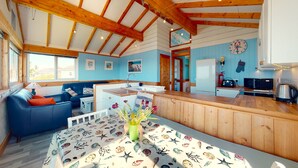 A cozy cabin interior with a dining area, kitchen, and living space. - F46 Holiday Haunt, Riviere Towans (HAYLE)